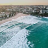 Manly Beach with foamy waves rolling and crashing at sunset