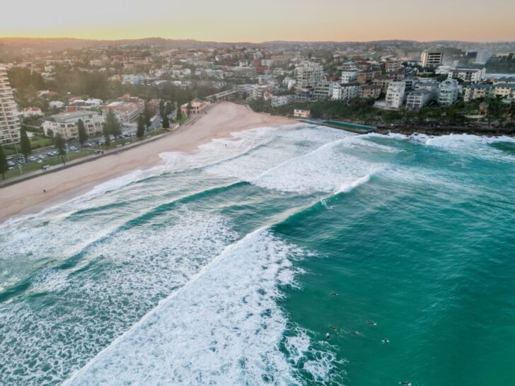 Manly Beach with foamy waves rolling and crashing at sunset